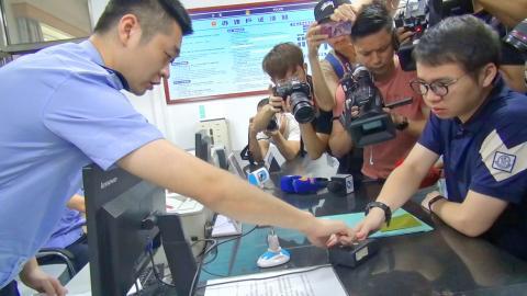 Un citoyen taiwanais laisse ses empreintes digitales alors qu'il demande une carte de résidence chinoise. Image CNA