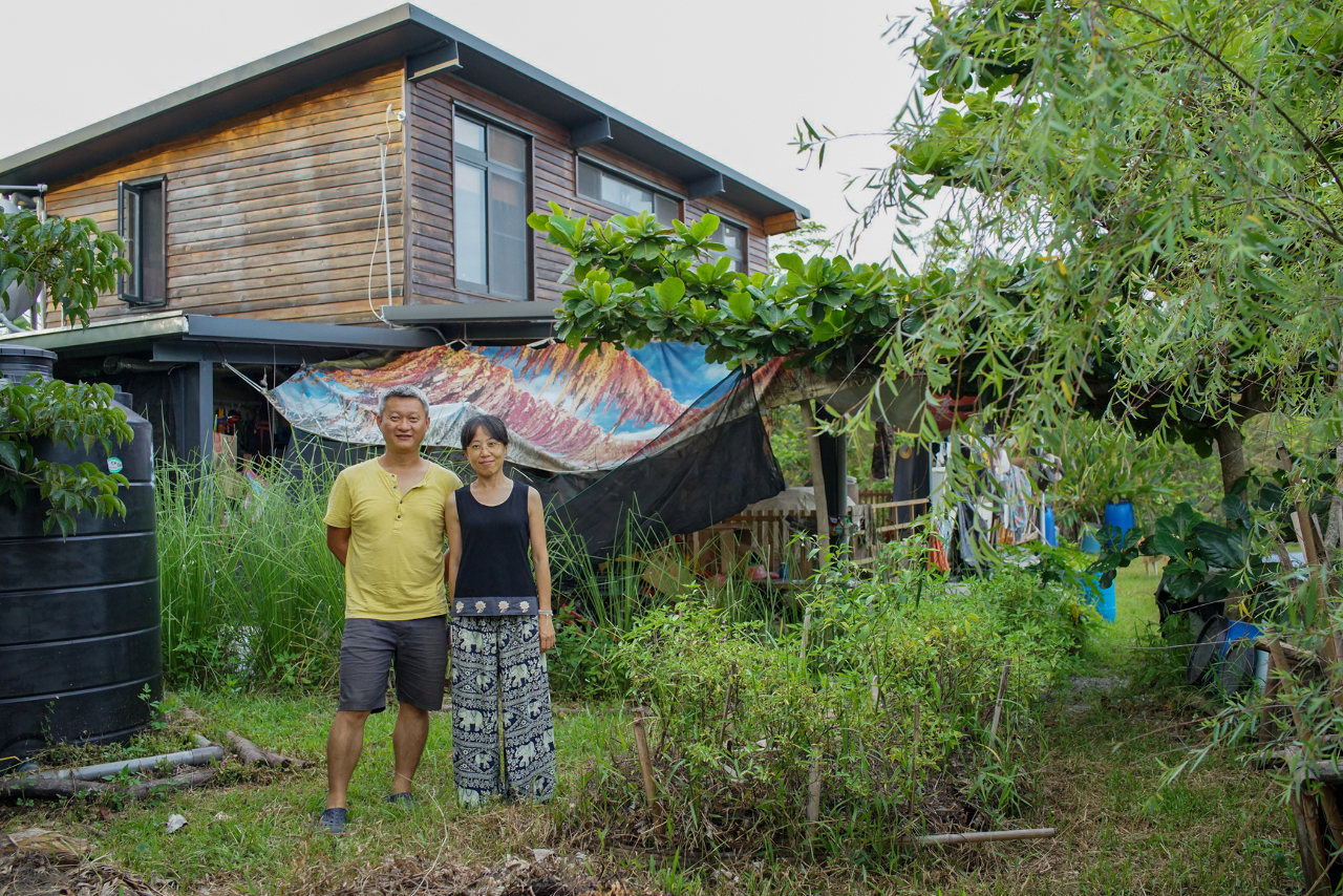 Jimmy, autoconstructeur, et sa femme Jen posent devant leur maison à Dulan (© Sasa)